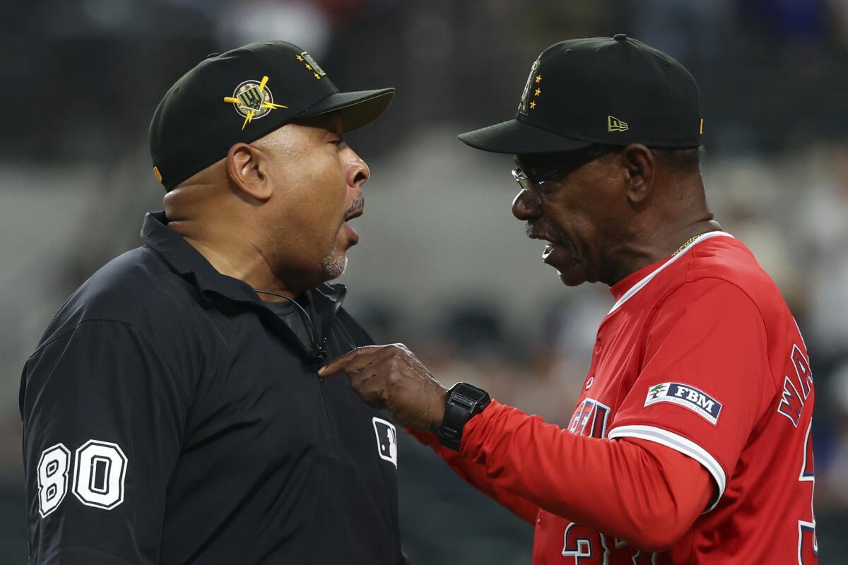 Third-base umpire Adrian Johnson and Angels manager Ron Washington argue.