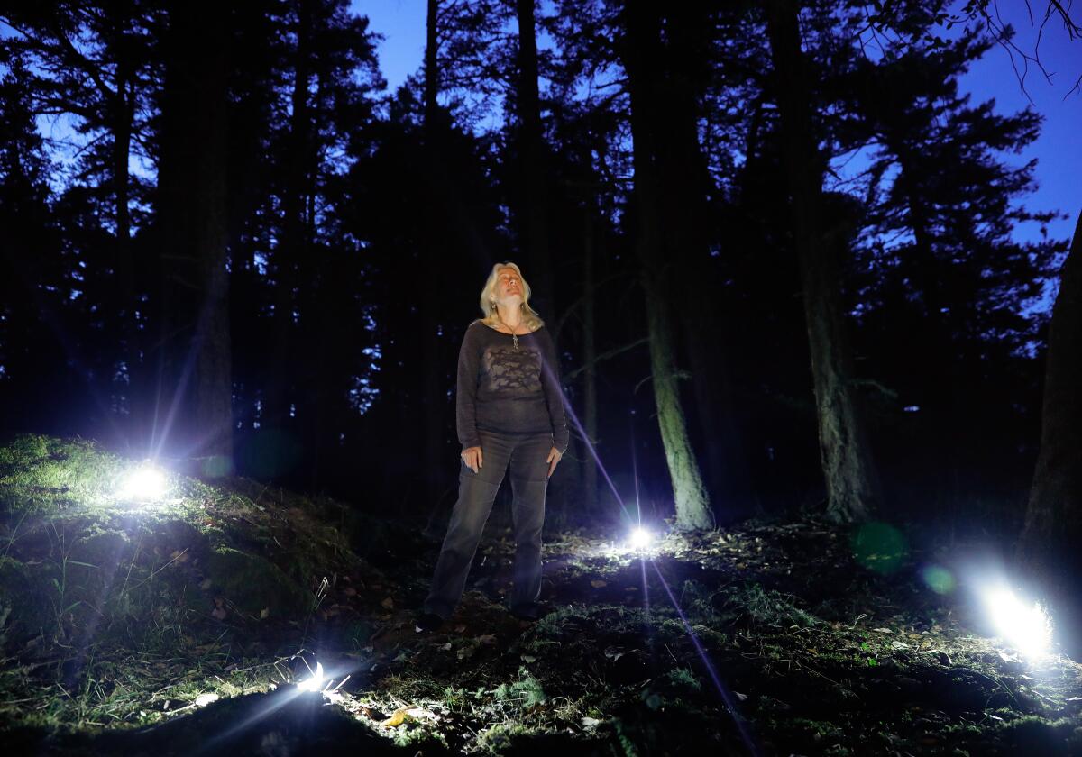 Blaire Van Valkenburgh places lanterns around the area where her late husband of 40 years Robert "Bob" Wayne's "soil" rests.