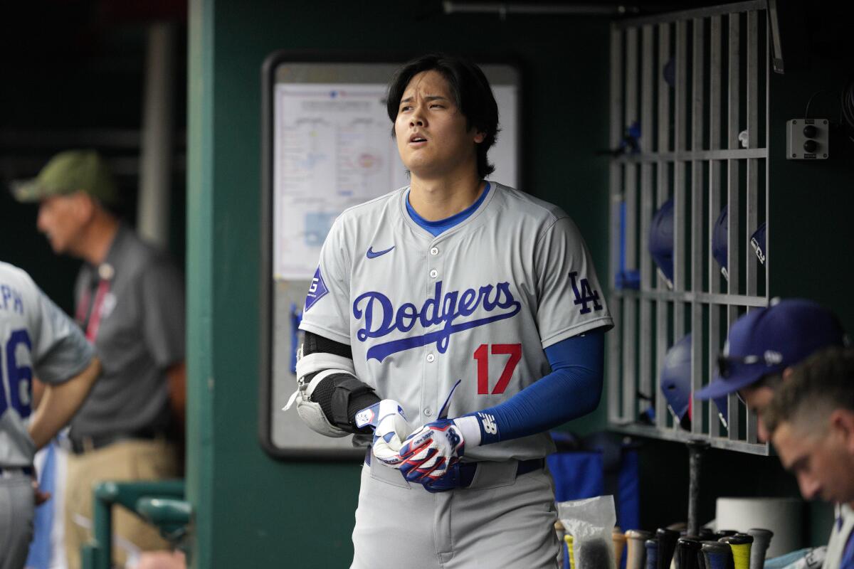 The Dodgers' Shohei Ohtani stands in the dugout after grounding out during the fourth inning against the Cincinnati Reds 
