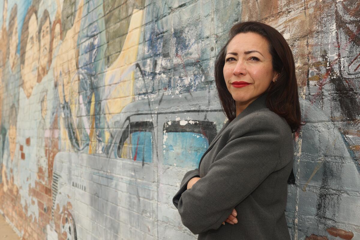 A woman poses with a mural