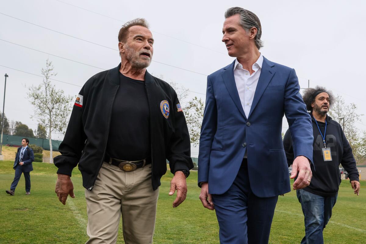 Gov. Gavin Newsom and former Gov. Arnold Schwarzenegger campaign against an oil industry ballot measure in March.