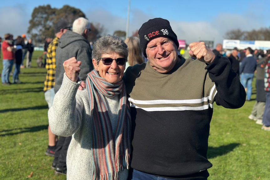 A man and woman with their fists in the air.