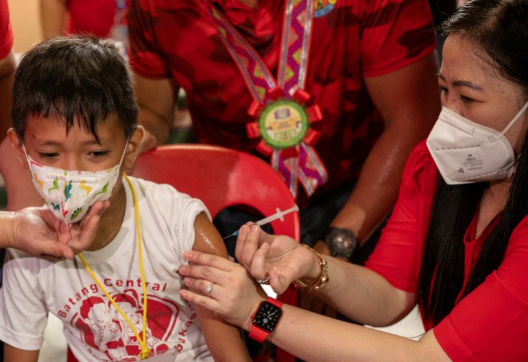 A student receives a dose of the Pfizer coronavirus disease (COVID-19) vaccine on the first day of in-person classes at a public school in San Juan City, Philippines, August 22, 2022. REUTERS/Eloisa Lope