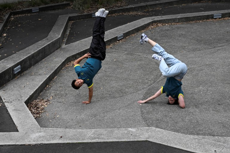 Two athletes breaking in a park.