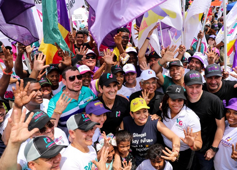 Romulo Roux stands amid a crowd of flag-waving supporters.