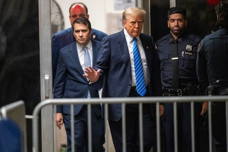 Donald Trump waves as he attends his hush money trial