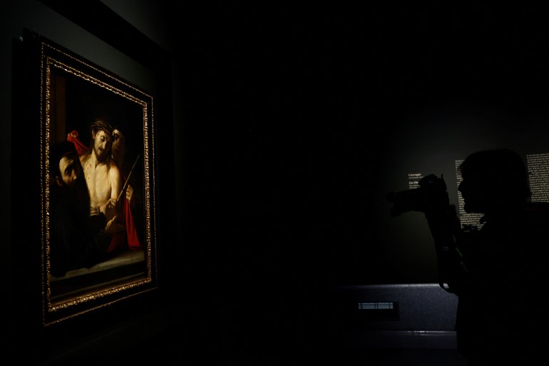 A photographer takes pictures of the painting "Ecce Homo" (Behold the Man) by Italian artist Caravaggio during a media presentation at Prado Museum in Madrid, Spain, May 27, 2024. REUTERS/Susana Vera