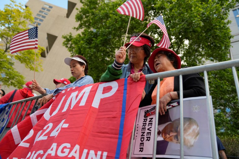 Trump supporters wave flags and hold banners outside the Manhattan court.