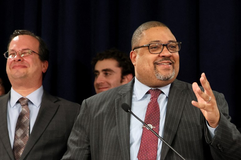 Alvin Bragg gestures as he speaks into a microphone at the podium.