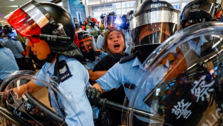 Riot police detain a woman in the midst of the pro-democracy protests in Hong Kong