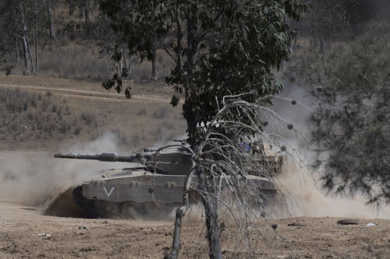 An Israeli army tank churns up dust as it returns to a forward staging area inside southern Israel near the border with the Gaza Strip on May 22, 2024. An Israeli strike on Rafah Sunday 35 people, the Gazan Health Ministry said. Photo by Jim Hollander/UPI