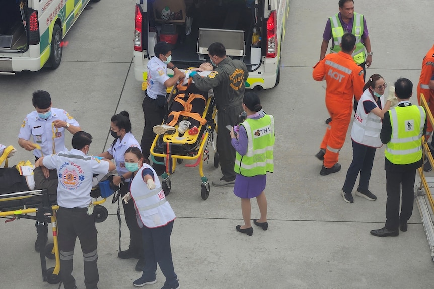 Emergency services attend to injured passengers on the tarmac. 