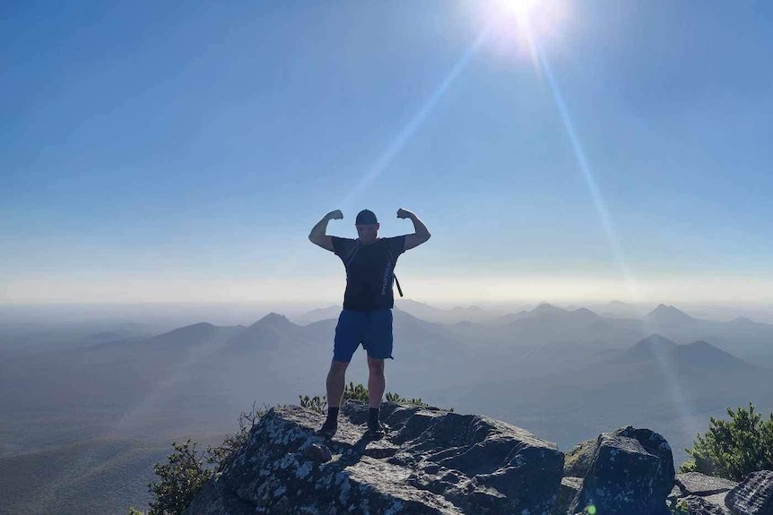 A man posing on a mountain.