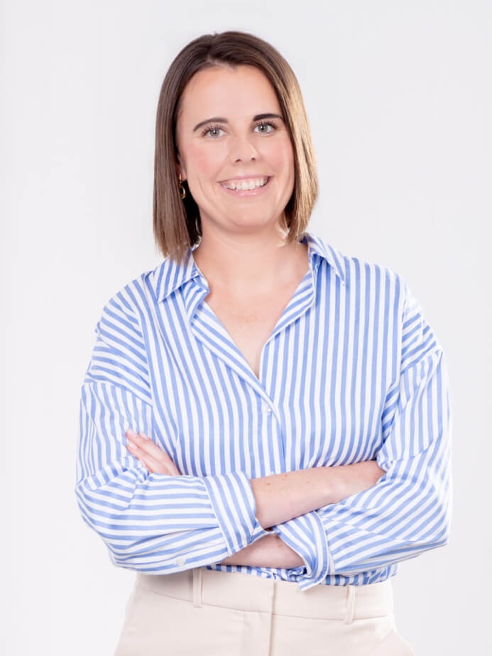 A professional portrait of buyer's advocate Emily Wallace. She's smiling as she crosses her arms.