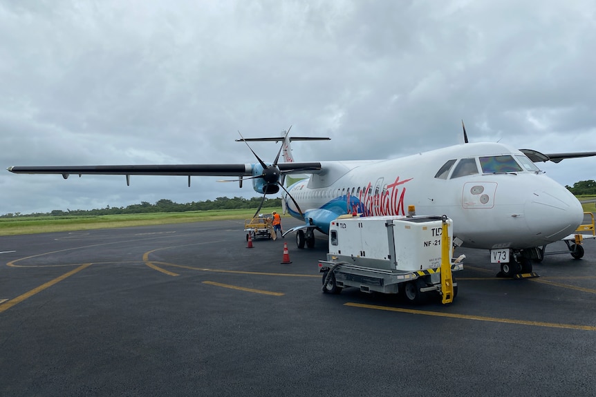 Airport workers load up an Air Vanuatu plane.