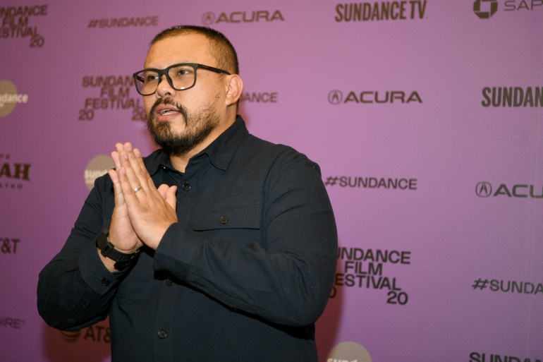 Joko Anwar. He has closely shaven hair, a dark beard and moustache and is wearing black-rimmed glasses and a black shirt. He has his hands clasped together.