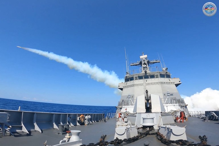 A missile taking off from a Philippines navy ship. It has left a trail of white smoke behind the bridge of the ship.