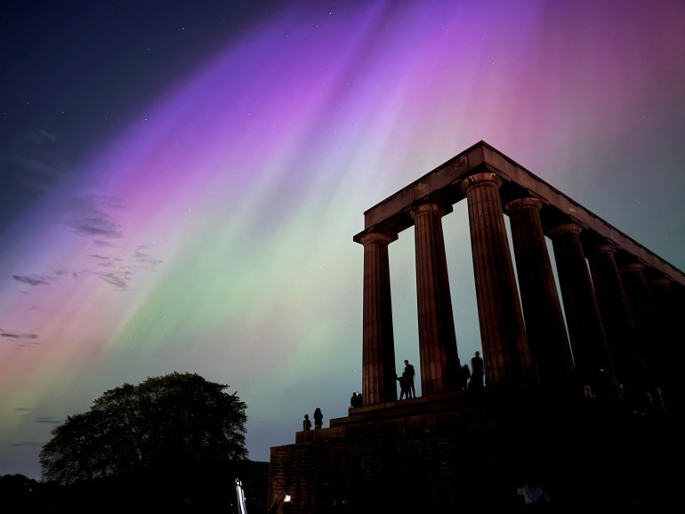 TOPSHOT - This handout photo taken and released by Jacob Anderson shows the northern lights or aurora borealis during a solar storm over the National Monument of Scotland in Edinburgh on May 10, 2024. The most powerful solar storm in more than two decades struck Earth on May 10, triggering spectacular celestial light shows in skies from Tasmania to Britain -- and threatening possible disruptions to satellites and power grids as it persists into the weekend. (Photo by Handout / Jacob Anderson / AFP) / RESTRICTED TO EDITORIAL USE - MANDATORY CREDIT "AFP PHOTO / JACOB ANDERSON" - NO MARKETING NO ADVERTISING CAMPAIGNS - DISTRIBUTED AS A SERVICE TO CLIENTS