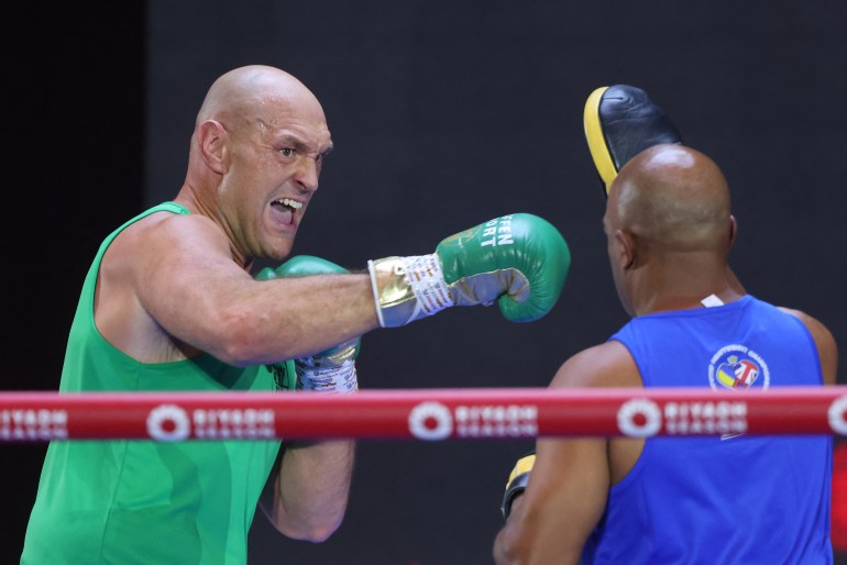 Boxer trains at gym with trainer.