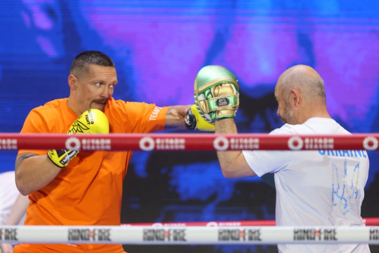 Boxer trains in gym with trainer.