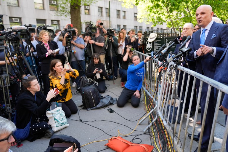 Arthur Aidala speaks to reporters behind a metal barricade outside in New York.