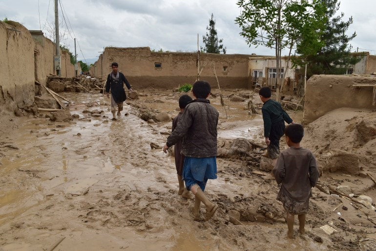 People walk near their damaged homes after heavy flooding in Baghlan province in northern Afghanistan Saturday, May 11, 2024. Flash floods from seasonal rains in Baghlan province in northern Afghanistan killed dozens of people on Friday, a Taliban official said. (AP Photo/Mehrab Ibrahimi)