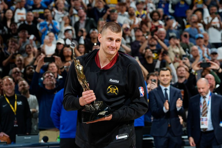 Denver Nuggets center Nikola Jokic smiles as he holds the trophy for being named NBA MVP, during a ceremony before Game 5 of the team's NBA basketball second-round playoff series against the Minnesota Timberwolves on Tuesday, May 14, 2024, in Denver (AP Photo/David Zalubowski)