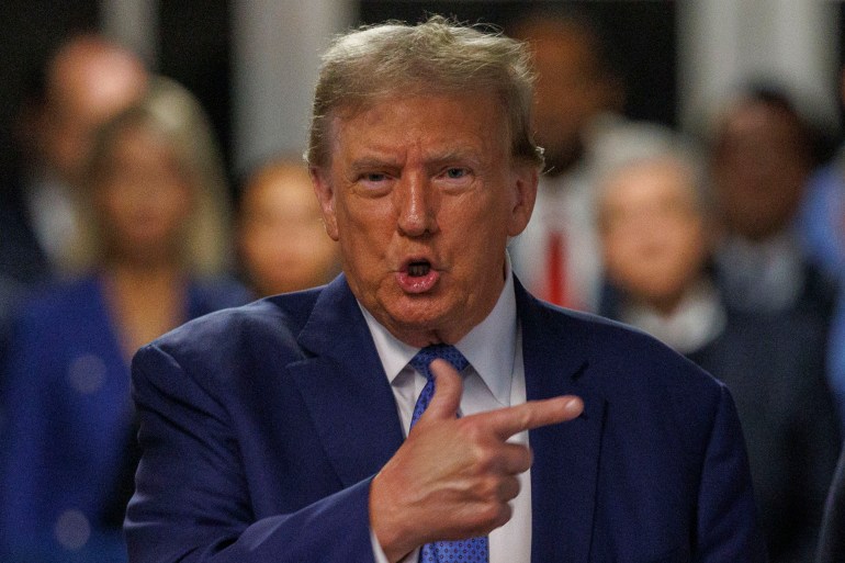 Donald Trump points with a finger as he speaks outside the Manhattan courtroom.