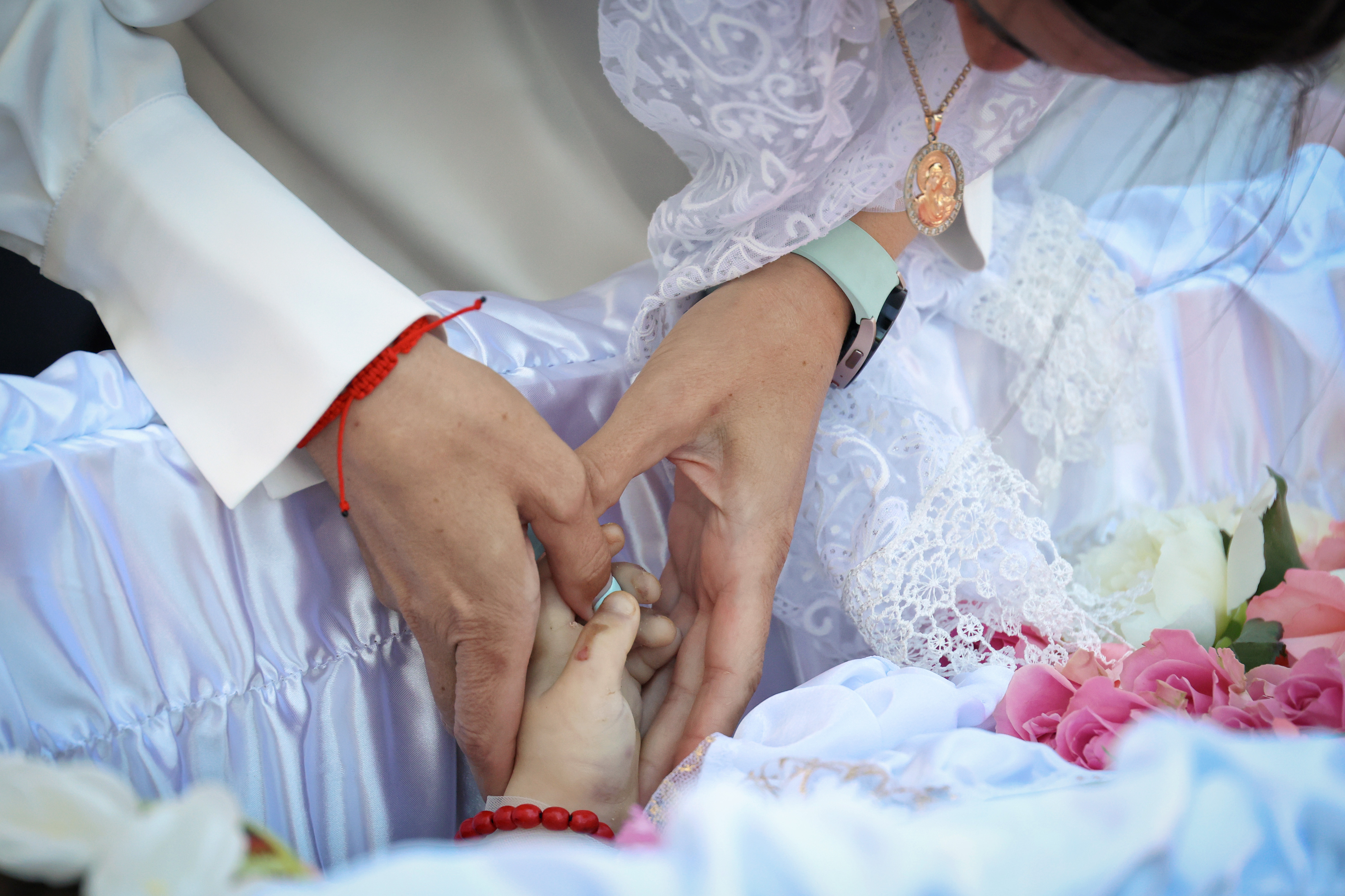 Nadiia Rostochyl holds her to her dead daughter's small hand