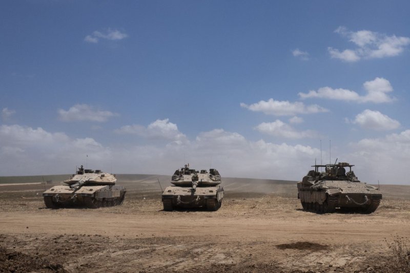 Israeli Merkava tanks and an armored personnel carrier pull into a front line staging area in southern Israel near the border with the Gaza Strip on May 13 as Israel continues its limited offensive in the Rafiah area of the southern Gaza Strip. Photo by Jim Hollander/UPI