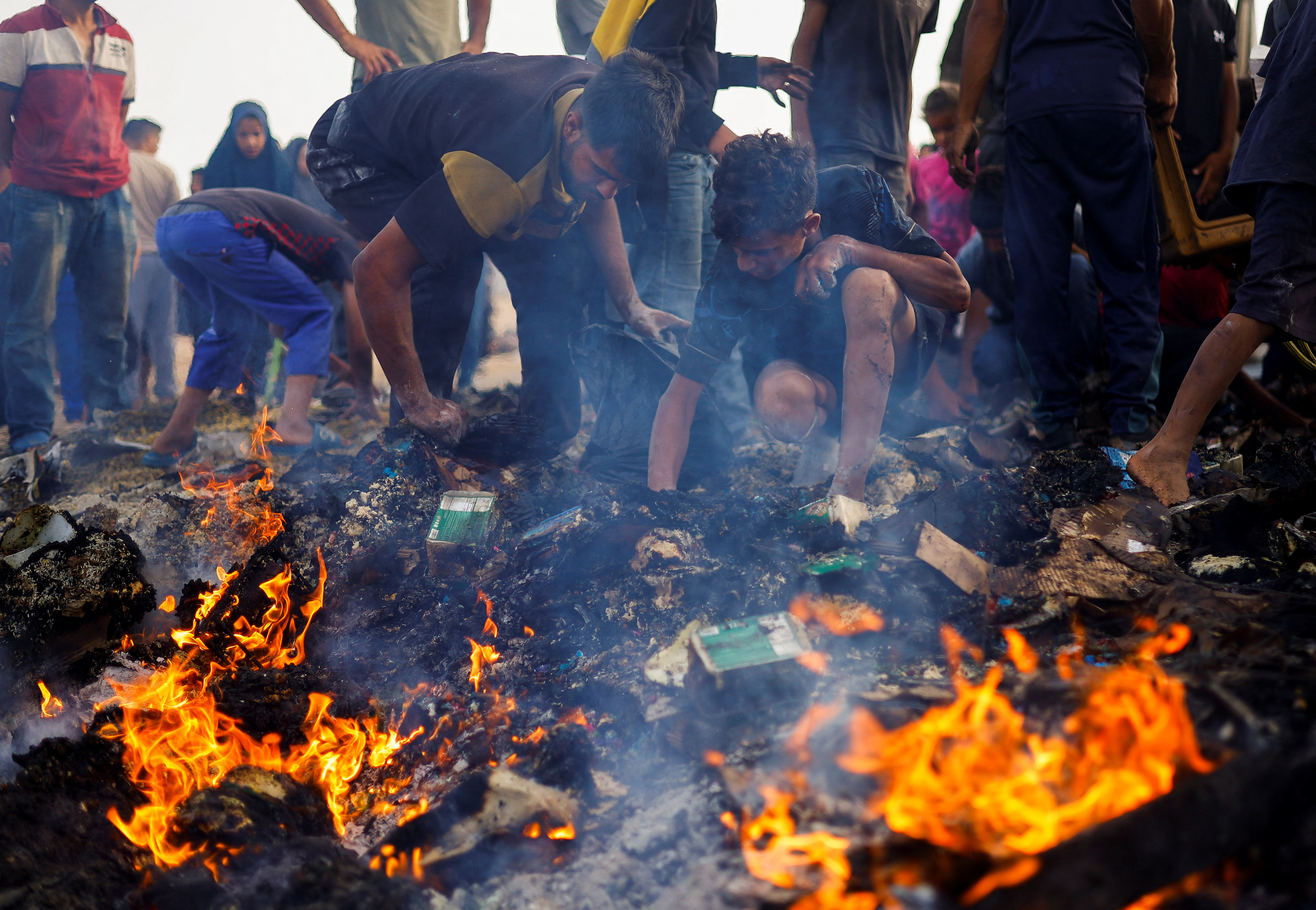 Palestinians search for food among burnt debris