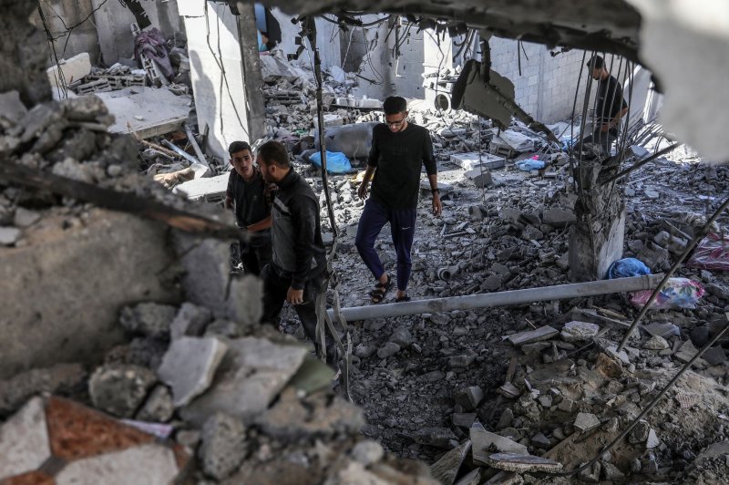 Palestinians inspect the aftermath of an Israeli airstrike in Rafah on Friday that killed seven members of one family, according to medical sources. Photo by Ismael Mohamad/UPI