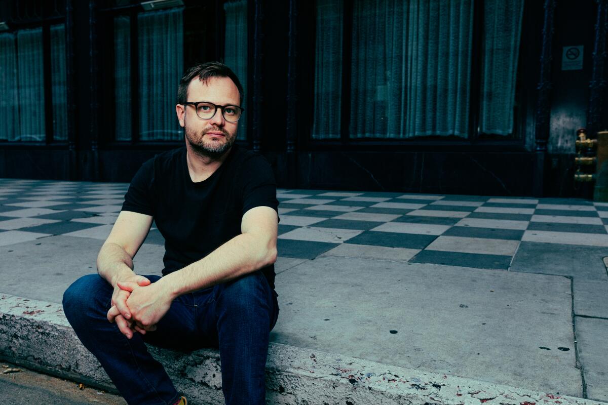 Meow Wolf's Sean Di Ianni, sitting on a downtown Los Angeles street.