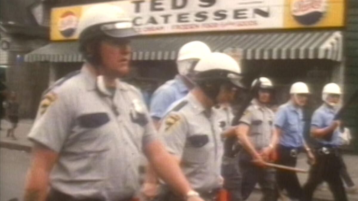 Cops proceed down a street.