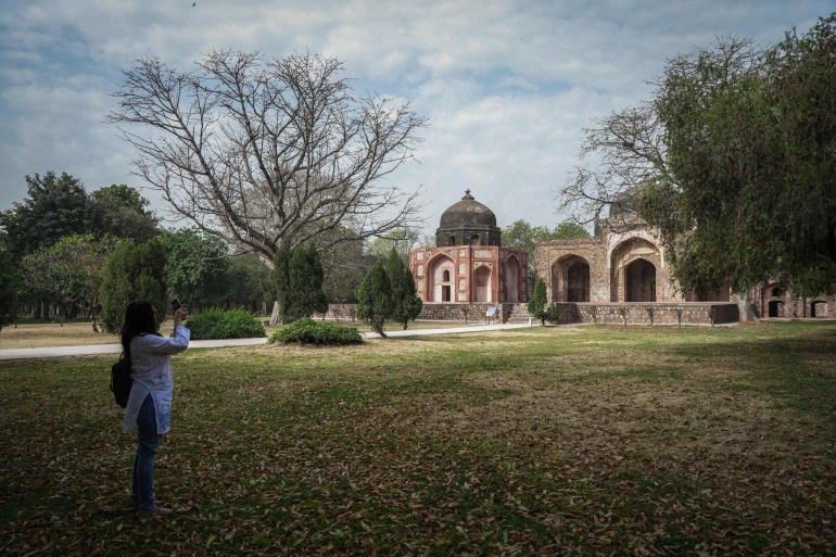 Sharma filming b-rolls of a Mughal-era monument for use in her YouTube broadcasts. (Md Meharban/Al Jazeera)