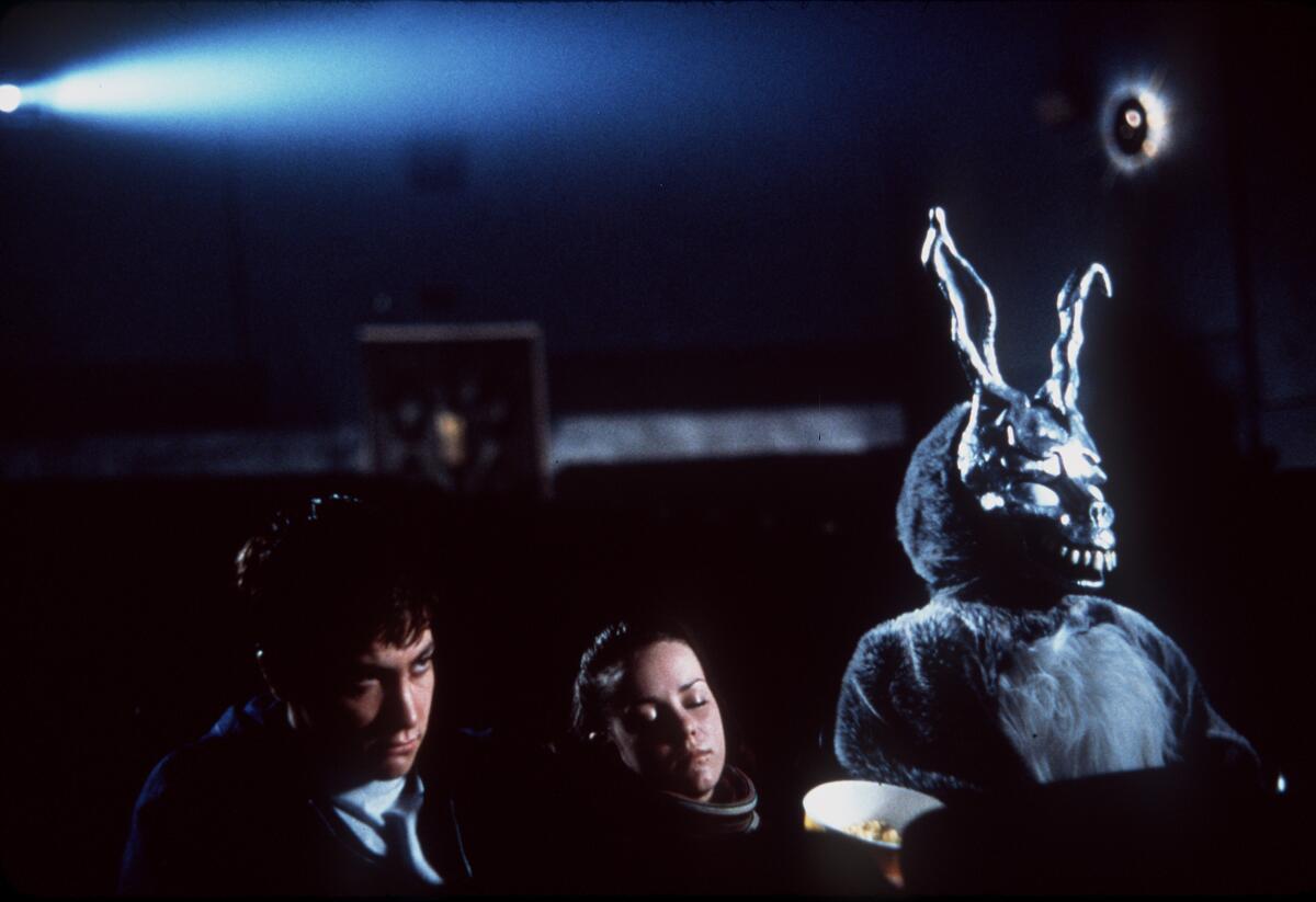 A man, a woman and a bunny sit in an empty movie theater.