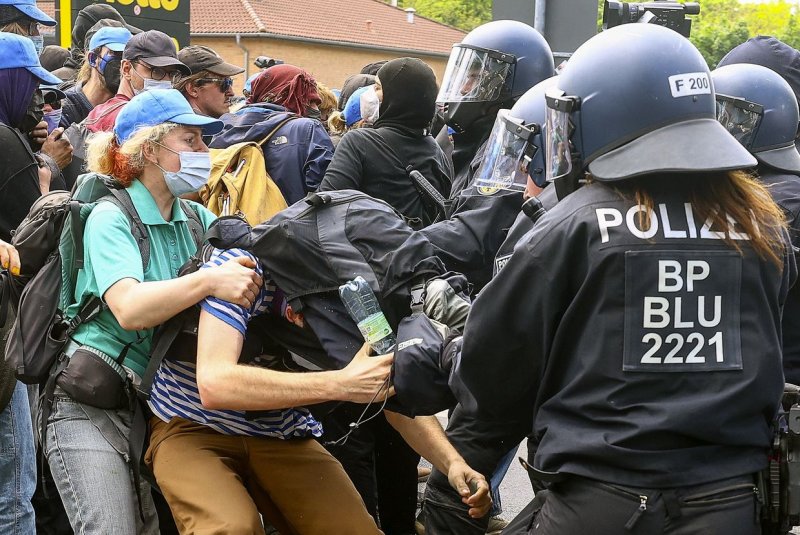 Police officers restrain environmental activists during a protest against Tesla's plans to extend its Gigafactory plant in Gruenheide, near Berlin, Germany, on Friday. Photo by Filip Singer/EPA-EFE