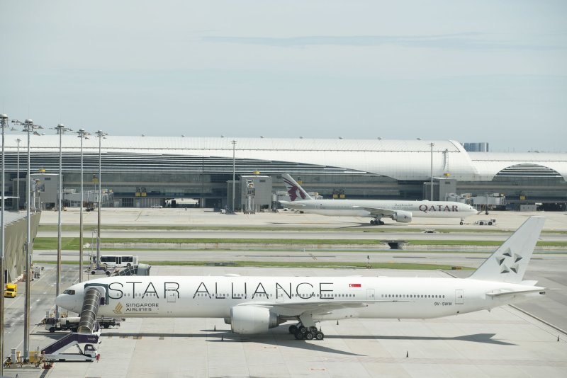 A Qatar Airways aircraft (back) taxies before taking off next to a Singapore Airlines plane flight from London to Singapore parked one day after diverting an emergency landing at Suvarnabhumi International Airport in Samut Prakan province, Thailand. Photo by Rungroj Yongrit/EPA-EFE