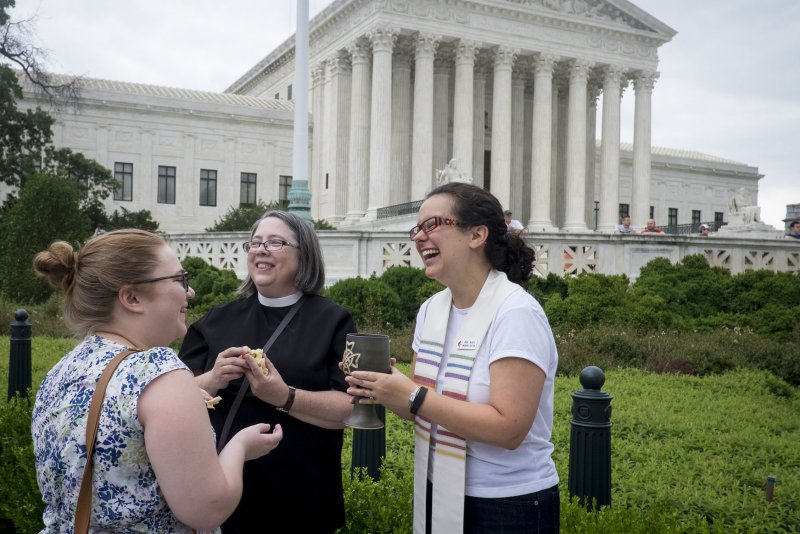 United Methodist Church delegates Wednesday lifted a 40-year ban on gay clergy. Another vote was expected later Wednesday removing a ban on church blessing of gay marriage. Members of the Dumbarton United Methodist Church pictured offering communion near the Supreme Court in Washington, D.C., after the Court's 5-4 ruling legalized gay marriage nationwide in 2015. File Photo by Pete Marovich/UPI