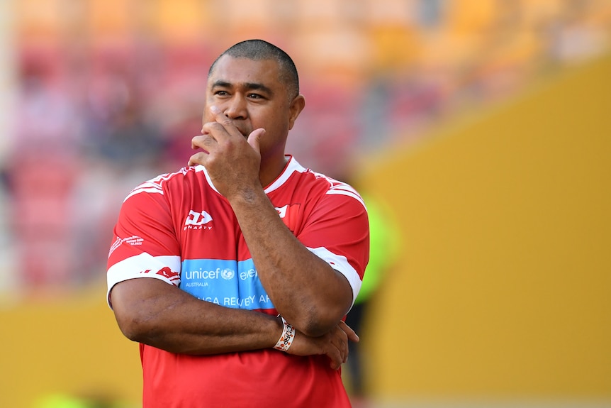 An image of Toutai Kefu wearing Tongan Rugby team mercandise folding his arm. 