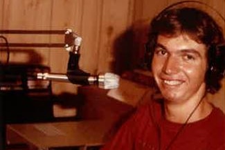 Smiling young man wearing headphones with microphone 