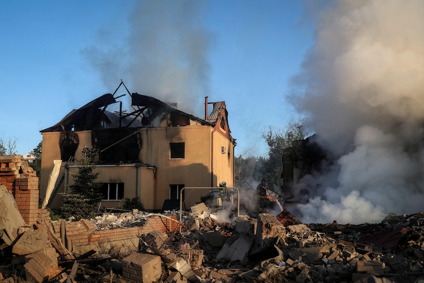 Firefighters searching through the rubble of houses that have been hit by missiles.