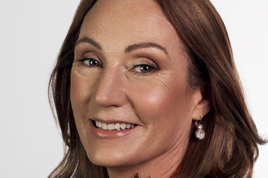 A profile image of a woman with shoulder-length brown hair, wearing a red shirt.