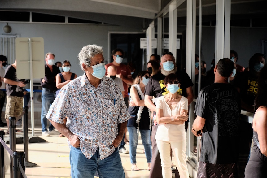 Masked voters wait in lines.