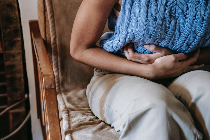 A person clutching their stomach. 