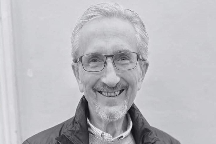 A black-and-white photo of an older man, smiling.