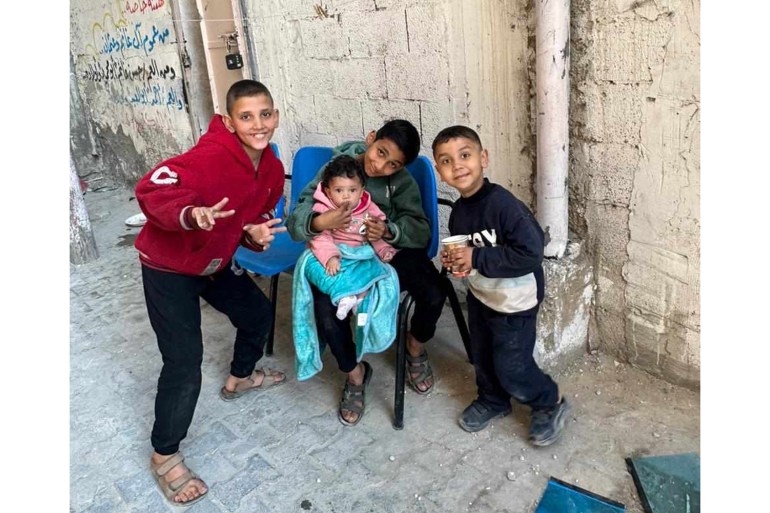 a photo of three children and one baby in a alleyway in Gaza