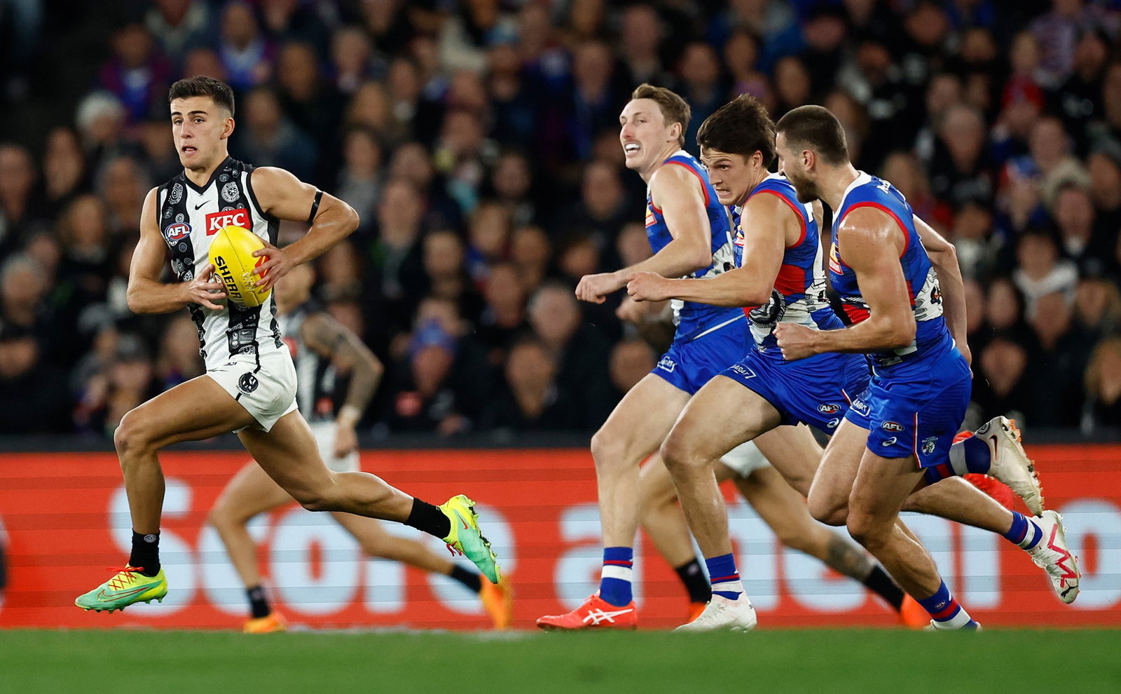 Nick Daicos runs away from Bulldogs players