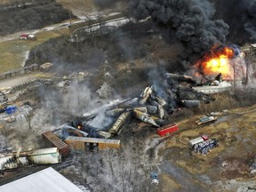 FILE - Debris from a Norfolk Southern freight train lies scattered and burning along the tracks on Feb. 4, 2023, the day after it derailed in East Palestine, Ohio. A federal judge has signed off Tuesday, May 21, 2024, on the $600 million class action settlement over last year's disastrous Norfolk Southern derailment in eastern Ohio, but many people who live near East Palestine are still wondering how much they will end up with out of the deal.