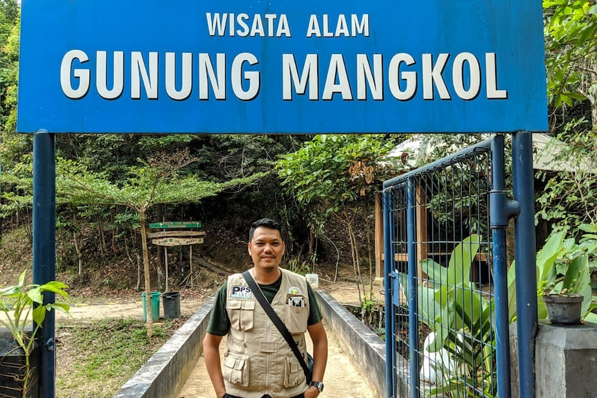 Endi Yusuf standing in front of a sign at Alobi Wildlife Rescue Centre.